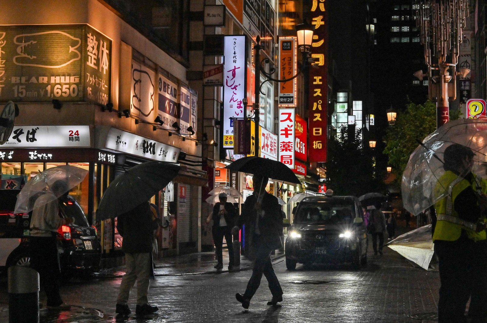 People walk down a street filled with restaurants and bars on a rainy evening in the entertainment area of Akasaka-Mitsuke in Tokyo, Japan, May 13, 2024. (AFP Photo)