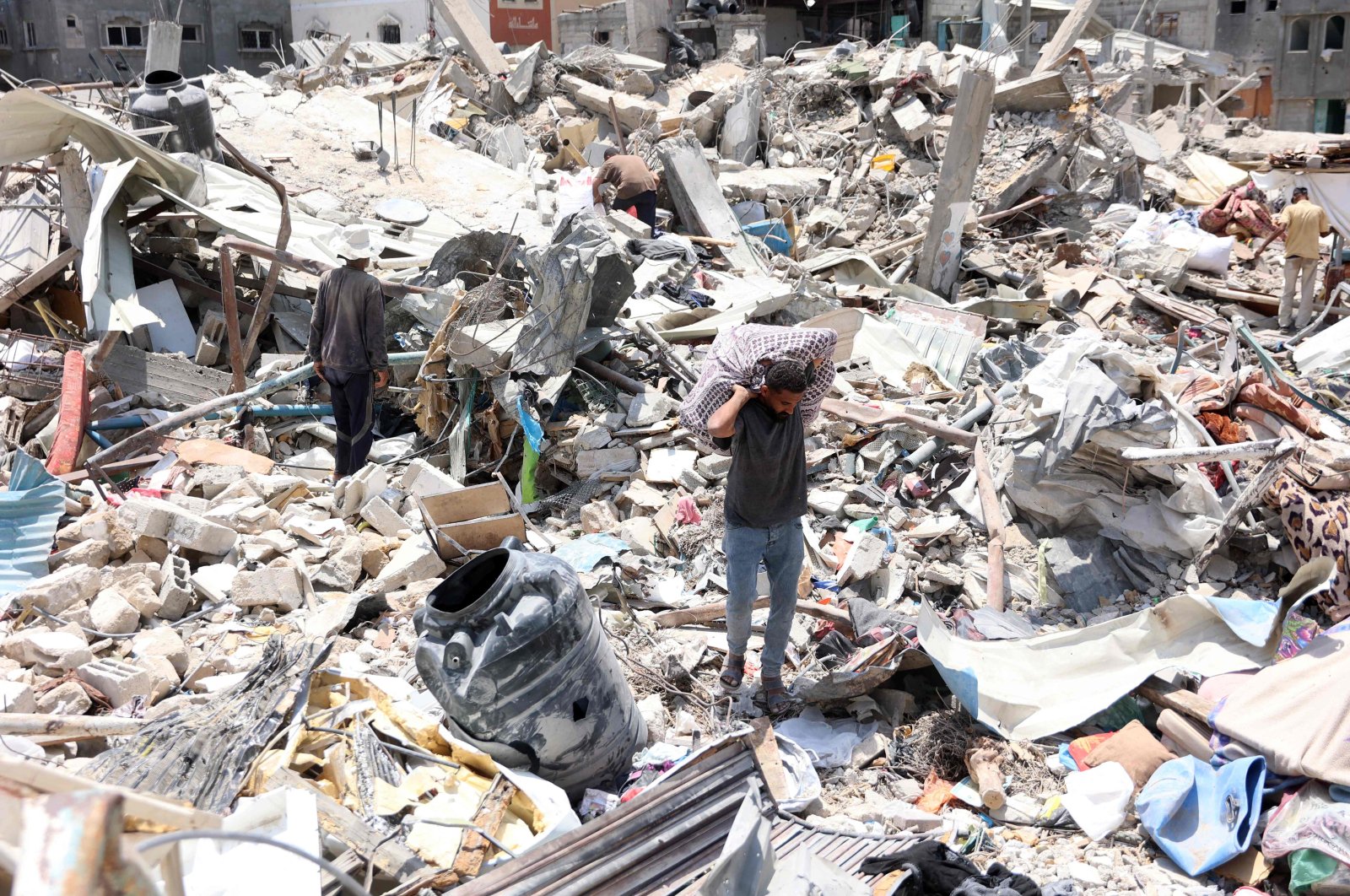 A Palestinian man carries a sheet containing goods he retrieved from under the rubble of destroyed buildings in the Jabalia refugee camp, northern Gaza Strip, Palestine, June 3, 2024. (AFP Photo)