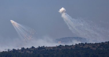A picture taken from the Israeli side of the border with Lebanon shows shells exploding over hills around the southern Lebanese village of Aita al-Shaab, Dec. 8, 2023. (AFP Photo)
