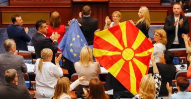 North Macedonian members of Parliament from the SDSM party, hold European Union and North Macedonian flags, during a parliamentary debate on a deal aimed at settling disputes with Bulgaria and clearing the way to EU membership, in Skopje, North Macedonia, July 16, 2022. (Reuters Photo)