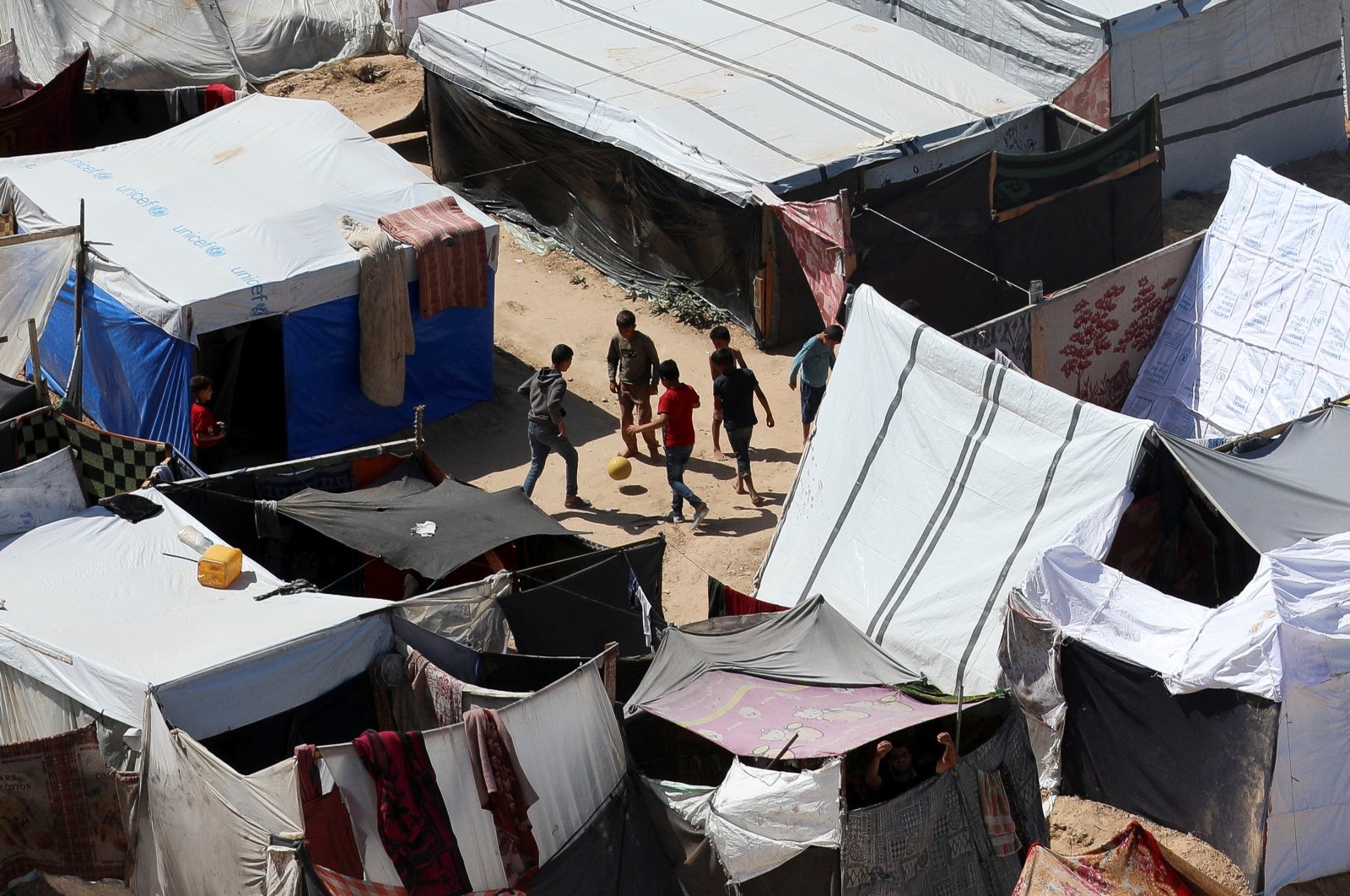 Displaced Palestinian boys, who fled their house due to Israeli strikes, play football as they shelter at a tent camp, amid the ongoing conflict, Deir al-Balah, Gaza Strip, Palestine, May 12, 2024. (Reuters Photo)