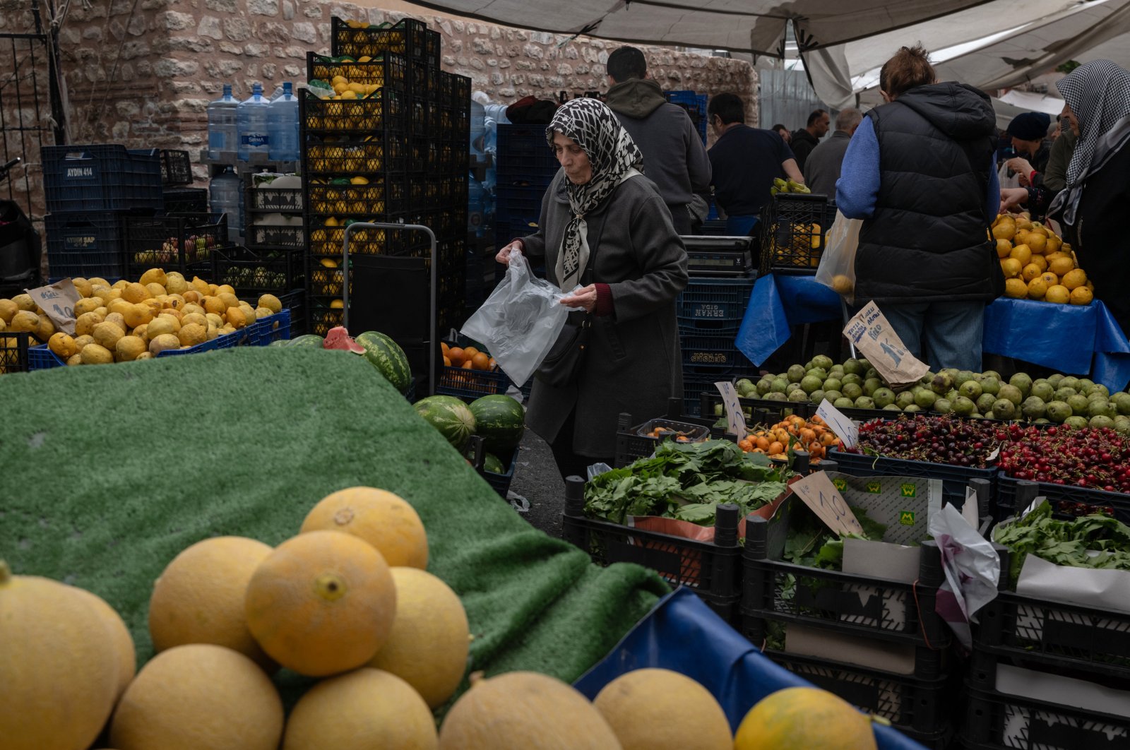 A customer selects fruit and vegetables at a Friday Bazaar market in Istanbul, Türkiye, May 10, 2024. (Getty Images Photo)