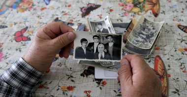 Turkish Bulgarian Seyfi Hacıali holds a family picture from his youth in Bulgaria before the forced expulsion of Turks in the 1980s, at an interview in his home, northwestern Kırklareli province, Türkiye, May 22, 2024. (AA Photo)