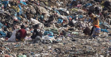 Internally displaced Palestinian children scavenge among waste accumulated near Khan Younis, southern Gaza Strip, May 18, 2024. (EPA File Photo)