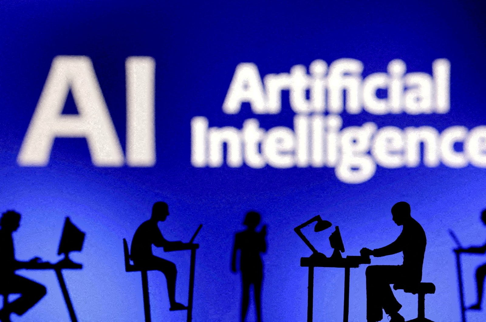 Figurines with computers and smartphones are seen in front of the words &quot;Artificial Intelligence AI&quot; in this illustration taken Feb. 19, 2024. (Reuters Photo)