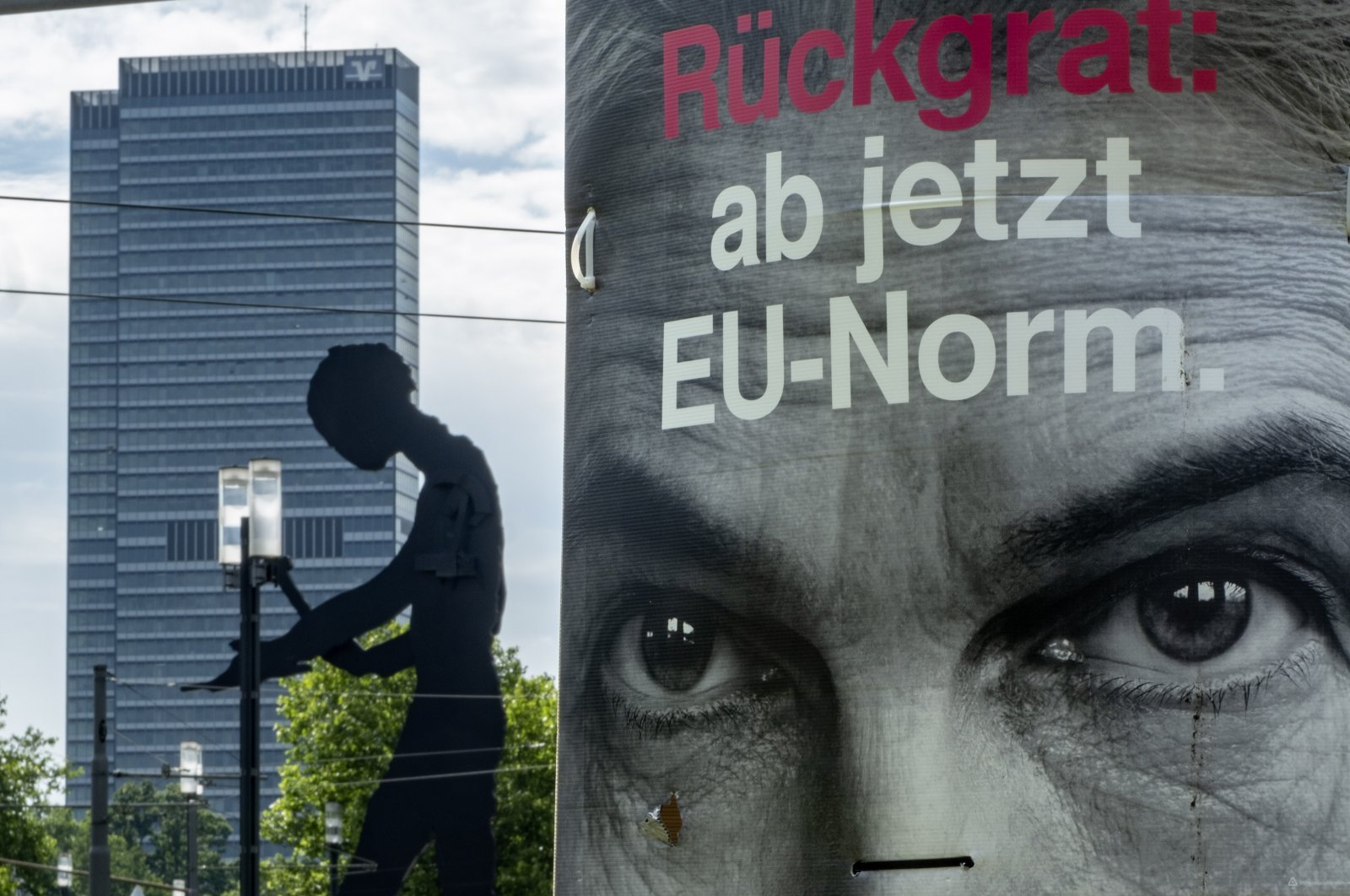 An election poster of Germany&#039;s Free Democratic Party&#039;s top candidate, Marie-Agnes Strack-Zimmermann fixed on a pole reads "spine: from now on EU norm" with "the hammering man", a statue by U.S. artist Jonathan Borofsky, is seen in the background, Frankfurt, Germany, June 5, 2024. (AP Photo)