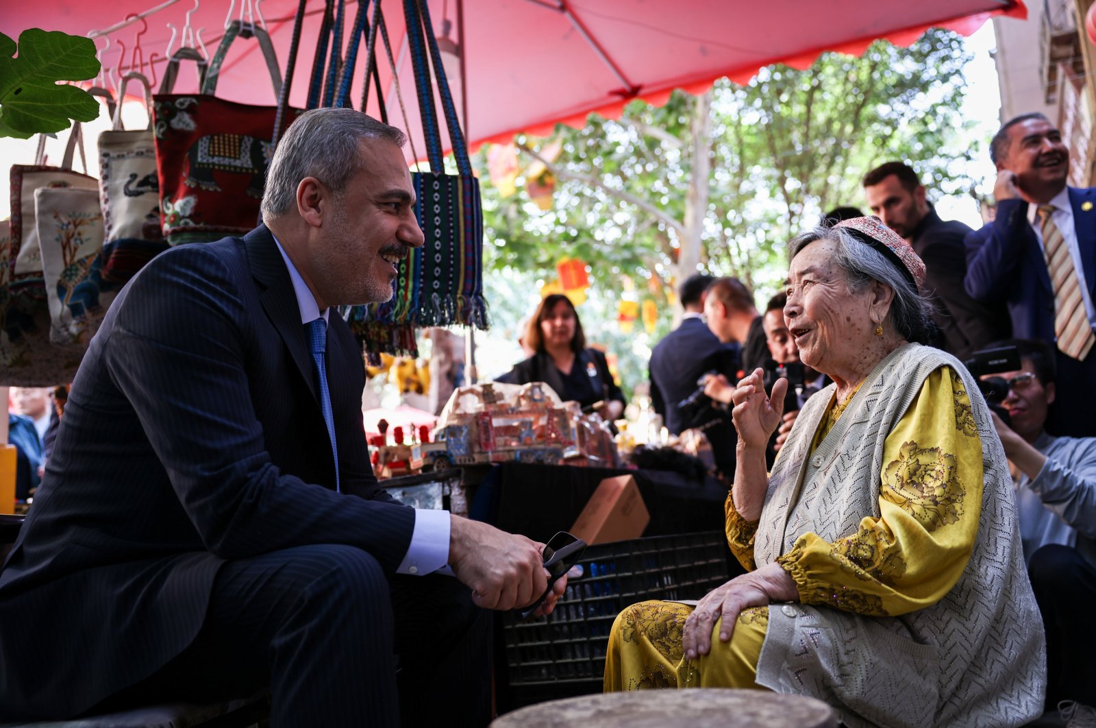 Foreign Minister Hakan Fidan talks to a woman during his tour in Kasghar, southern Xinjiang, China, June 5, 2024. (AA Photo)