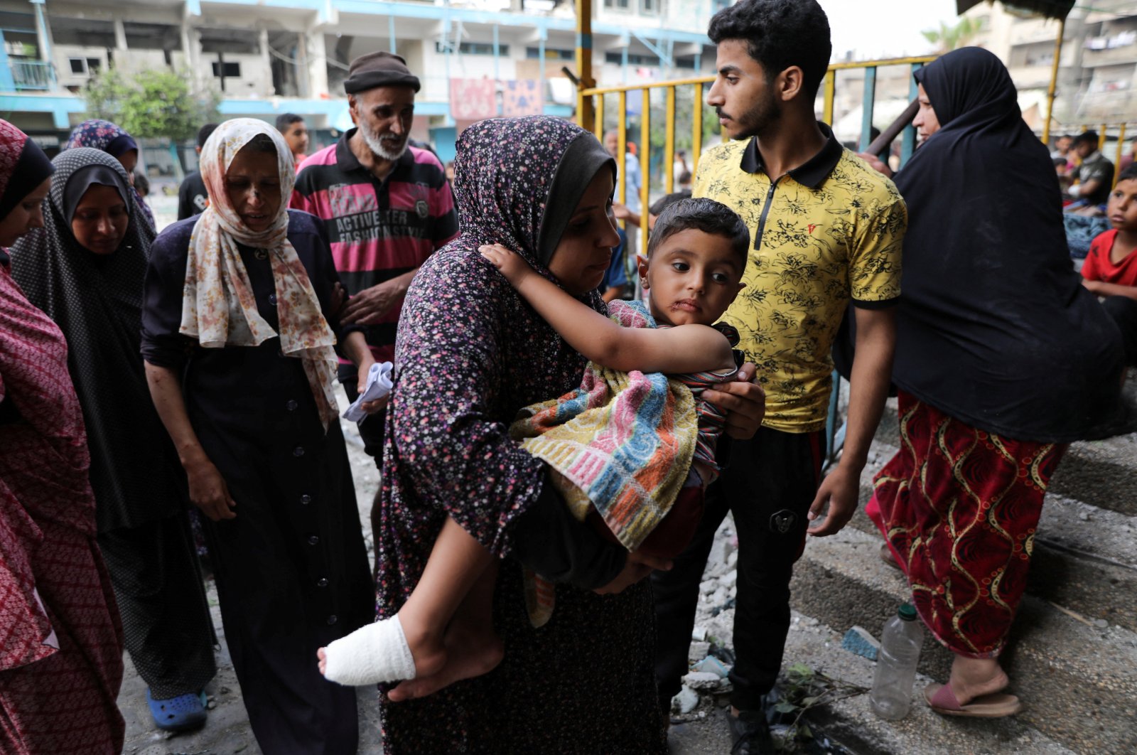 A woman carries a child at the site of an Israeli strike on a UNRWA school sheltering displaced people in Nuseirat refugee camp, amid the Israeli attacks on Gaza, Gaza Strip, Palestine, June 6, 2024. (Reuters Photo)