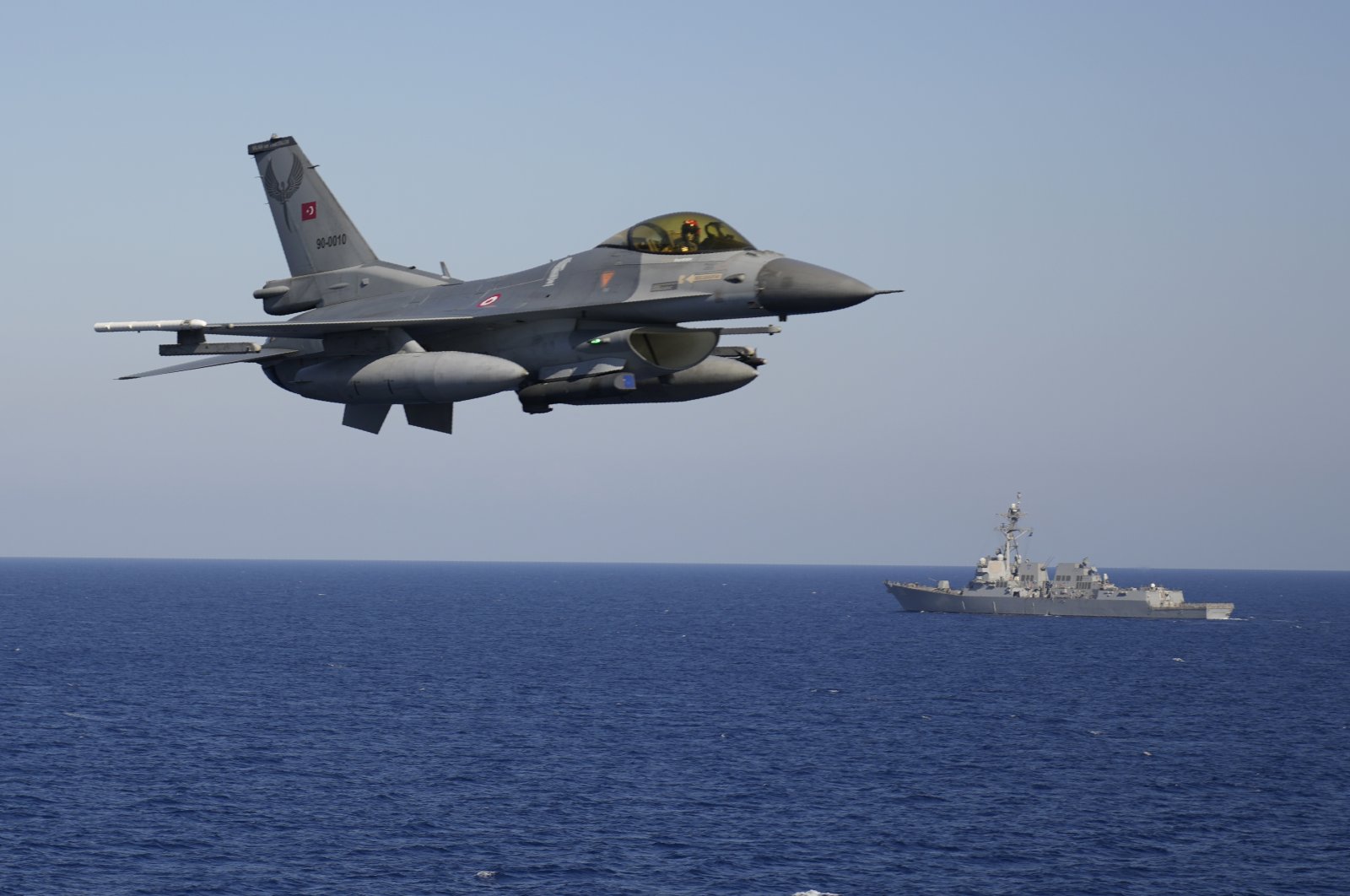 A Turkish F16 fighting jet flies over naval ships during an annual NATO naval exercise on Türkiye&#039;s western coast on the Mediterranean, Sept. 15, 2022. (AP Photo)