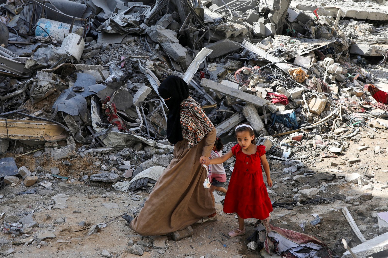 A woman and child walk among debris in the aftermath of Israeli strikes in Nuseirat refugee camp in the central Gaza Strip, Palestine, June 9, 2024. (Reuters Photo)