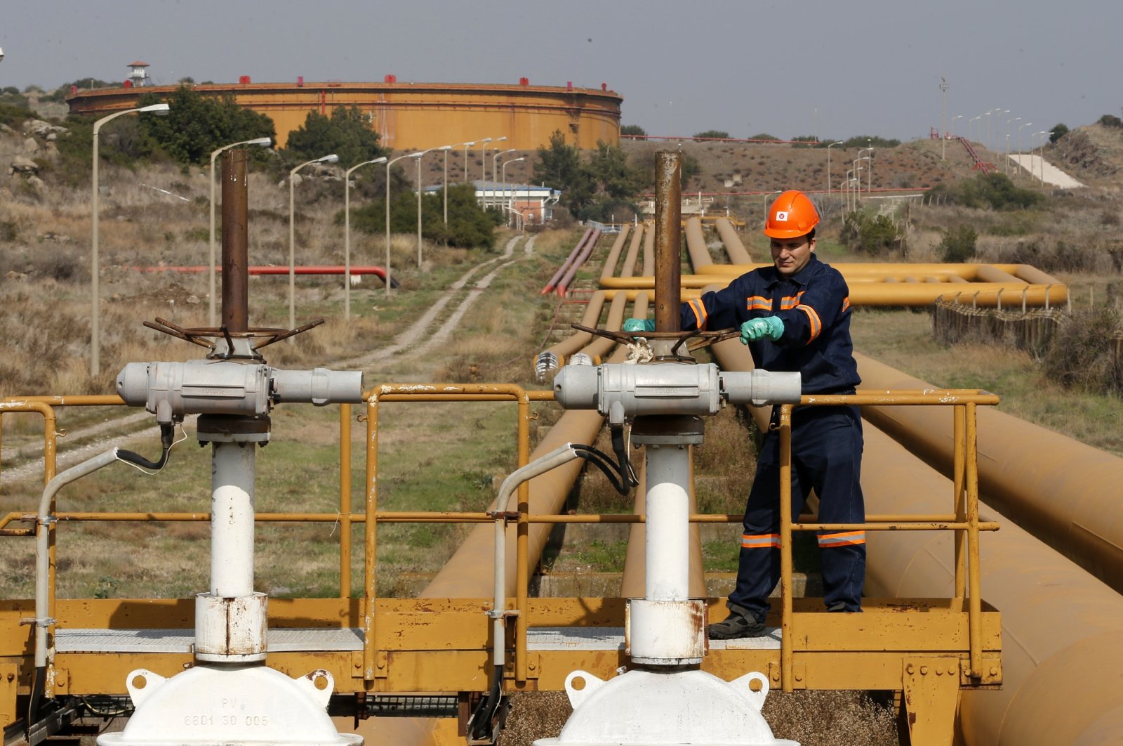 A worker checks the valve gears of pipes linked to oil tanks at the Mediterranean port of Ceyhan, some 70 kilometers (43.5 miles) from Adana province, southern Türkiye, Feb. 19, 2014. (Reuters Photo)