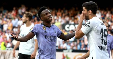 Real Madrid's Brazilian forward Vinicius Junior (L) talks to Valencia's Turkish defender Cenk Özkacar as he reacts to being insulted from the stands during the La Liga match at the Mestalla stadium, Valencia, Spain, May 21, 2023. (AFP Photo)