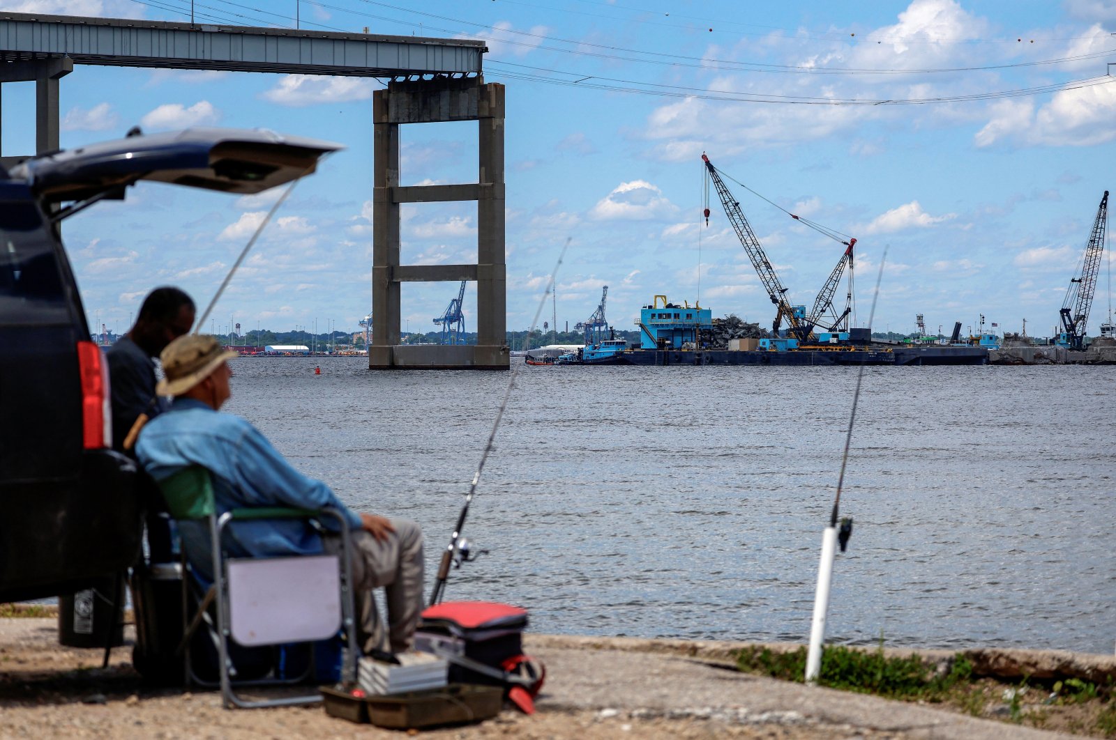 Men fish at Fort Armistead Park while clean-up operations continue around the Francis Scott Key Bridge as the main shipping channel prepares to fully reopen in Baltimore, Maryland, U.S., June 10, 2024. (Reuters Photo)