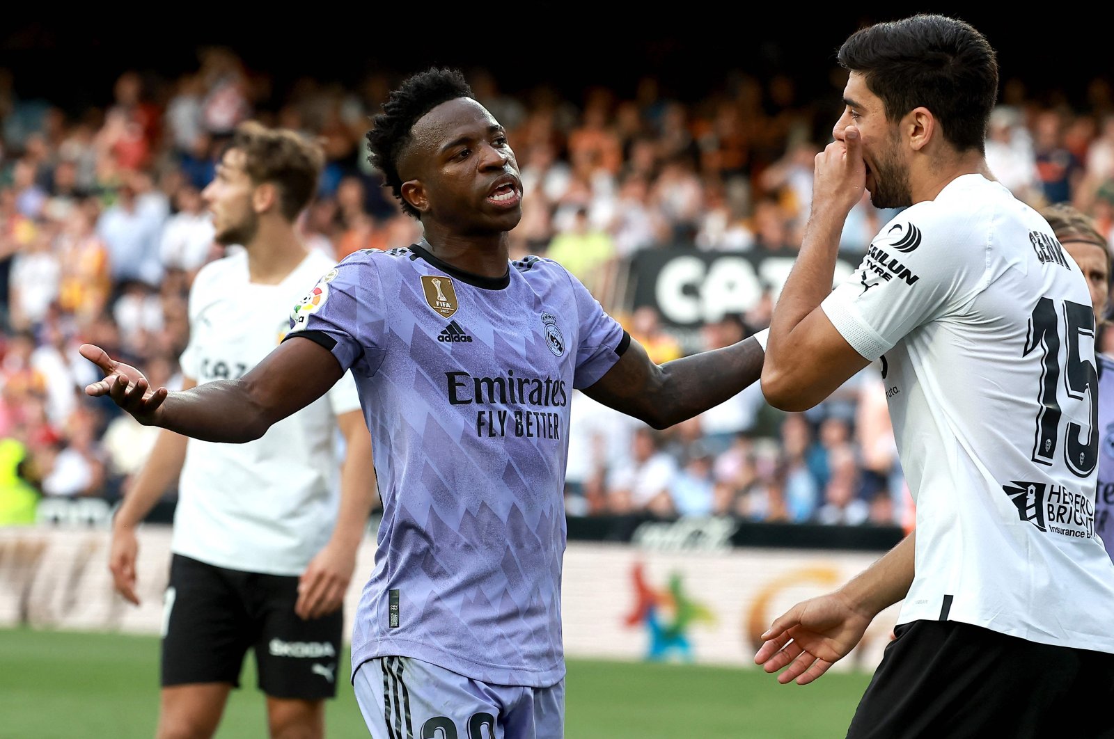 Real Madrid&#039;s Brazilian forward Vinicius Junior (L) talks to Valencia&#039;s Turkish defender Cenk Özkacar as he reacts to being insulted from the stands during the La Liga match at the Mestalla stadium, Valencia, Spain, May 21, 2023. (AFP Photo)