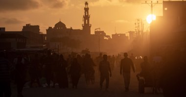 Palestinians walk at sunset in a street of Khan Younis refugee camp after it was targeted by Israeli bombardments, southern Gaza Strip, Palestine, June 11, 2024. (EPA Photo)