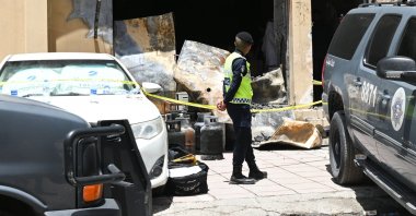 A Kuwaiti policeman stands in front of the residential building after a fire broke out in Mangaf, Kuwait, June 12, 2024. (EPA Photo)