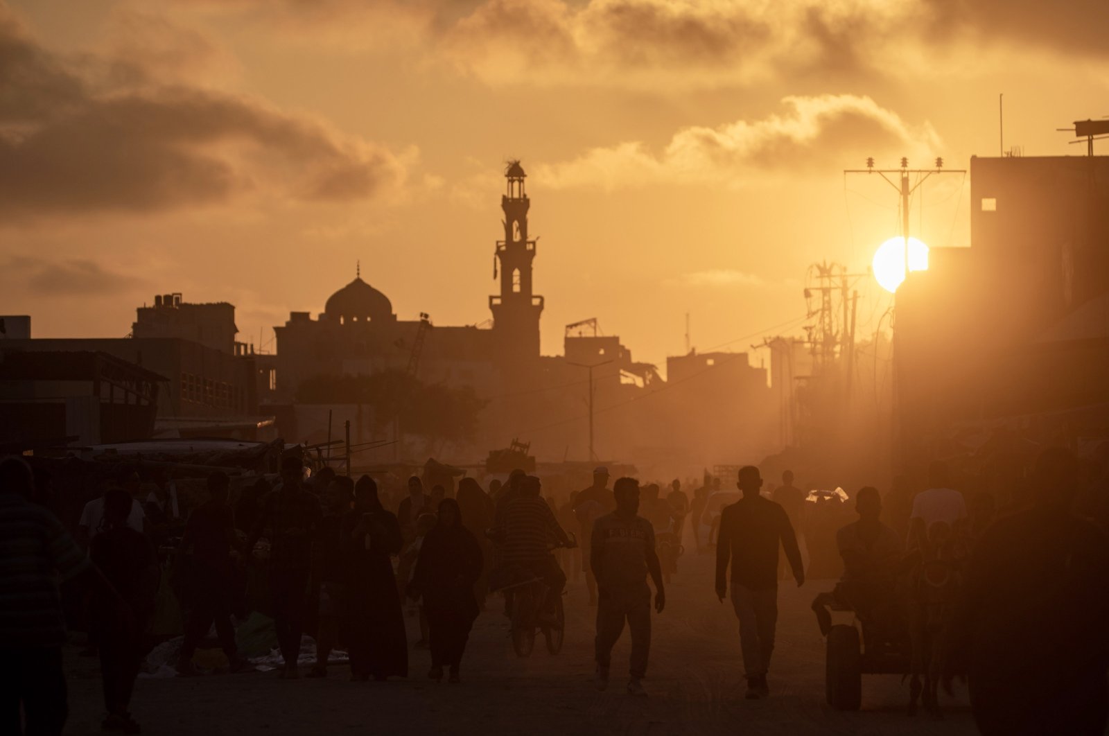 Palestinians walk at sunset in a street of Khan Younis refugee camp after it was targeted by Israeli bombardments, southern Gaza Strip, Palestine, June 11, 2024. (EPA Photo)