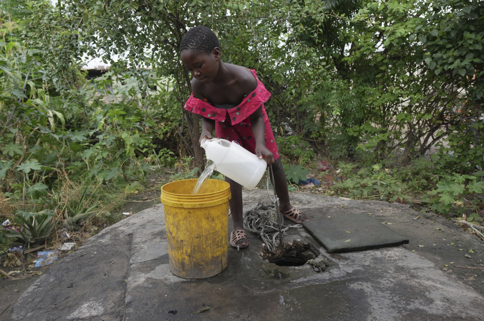 A young girl fetches water from a well in Lilanda township, Lusaka, Zambia, March 9, 2024. (AP Photo)