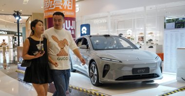People walk beside a NIO ET5 electric car on display in a shopping mall, Beijing, China, June 13, 2024. (EPA Photo)