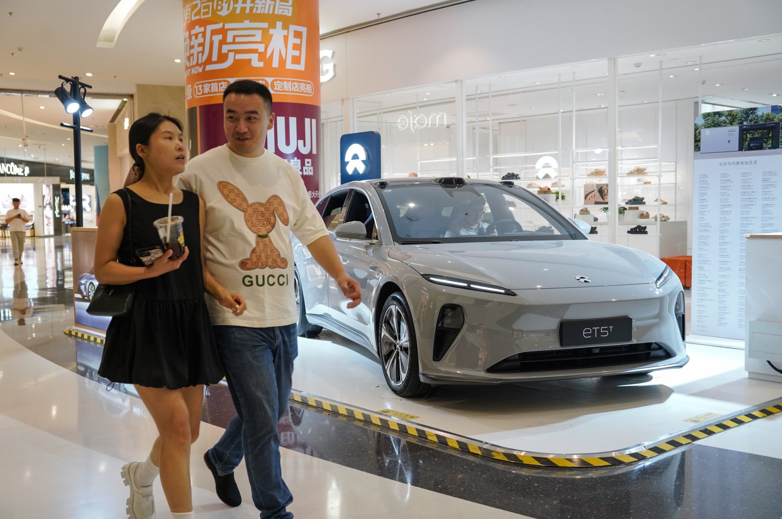 People walk beside a NIO ET5 electric car on display in a shopping mall, Beijing, China, June 13, 2024. (EPA Photo)