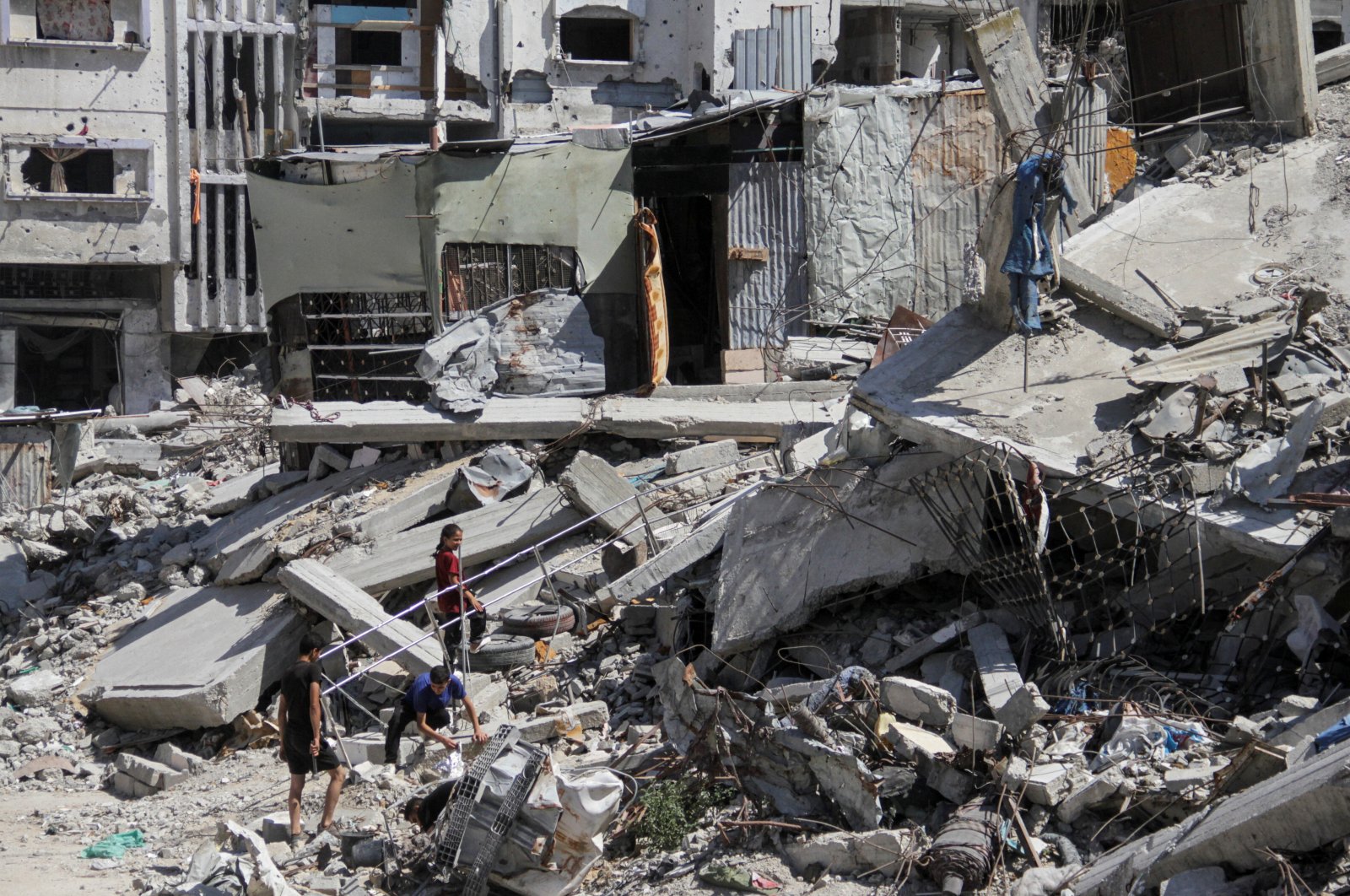 Palestinians walk among the rubble of damaged buildings, which were destroyed during Israel&#039;s attacks, Gaza, Palestine, June 12, 2024. (Reuters Photo)