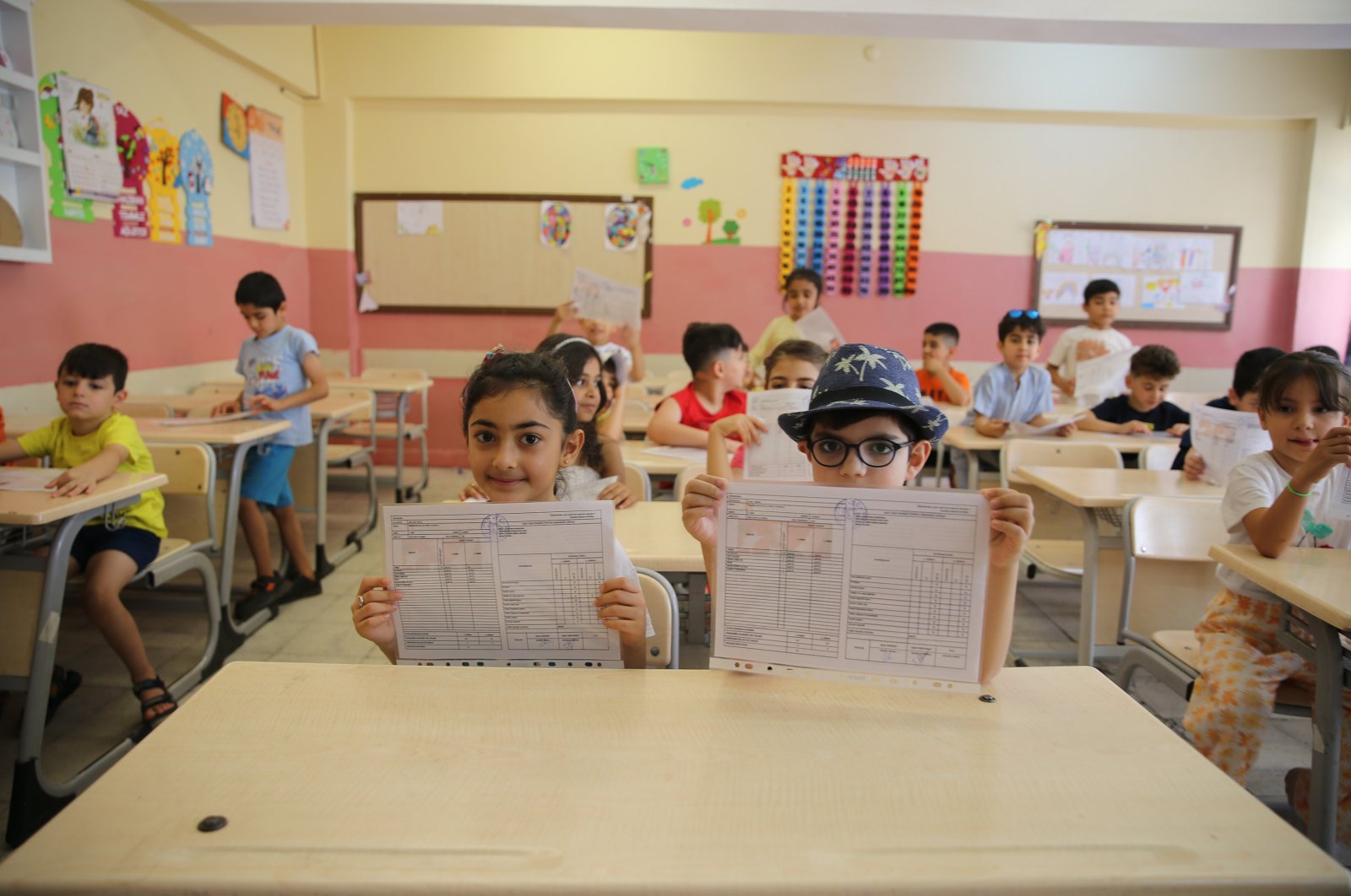 Students pose with their report card following the end of the school year, Mardin, southeastern Türkiye, June 14, 2024. (AA Photo)