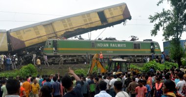 Onlookers watch as National Disaster Response Force (NDRF) rescuers work at the site of a train collision, near Rangapani station, West Bengal state, India, June 17, 2024. (EPA Photo)