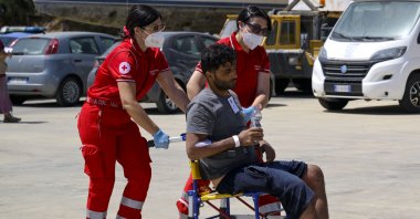 One of the 11 migrants saved from the sea is assisted by emergency workers in Roccella Ionica, southern Italy, June 17, 2024. (AP Photo)