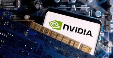 A smartphone with a Nvidia logo is placed on a computer motherboard in this illustration taken March 6, 2023. (Reuters Photo)