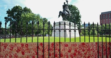A banner with red handprints, left by pro-Palestinian demonstrators, sits as the base of a statue of Andrew Jackson in Lafayette Squre near the White House during a protest against Israel's actions in Gaza, in Washington, DC, US, June 8, 2024. (AFP Photo)