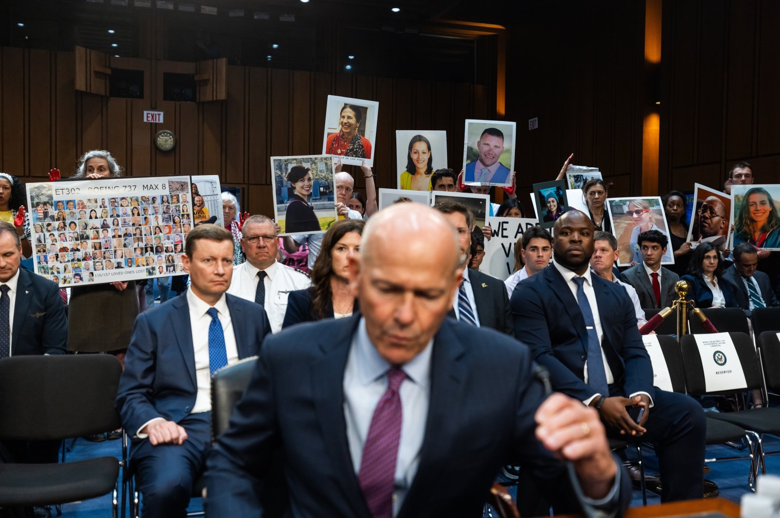 Relatives who lost loved ones in the crash of a Boeing aircraft stand behind outgoing Boeing CEO David Calhoun as he prepares to testify before a U.S. Senate committee amid an ongoing safety investigation into the airline manufacturer, Washington, D.C., U.S., June 18, 2024. (EPA Photo)
