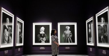 A gallery worker poses with a painting of Catherine Parr by an unknown painter during a preview of the exhibition "Six Lives: The Stories of Henry VIII's Queens" at the National Portrait Gallery, London, U.K., June 19, 2024. (EPA Photo)