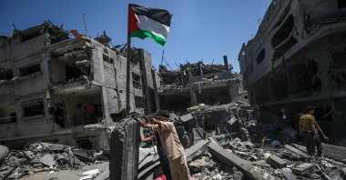 Palestinians raise a Palestinian flag next to their destroyed house following an Israeli airstrike at al-Bureij refugee camp, southern Gaza Strip, Palestine, June 18, 2024. (EPA Photo)