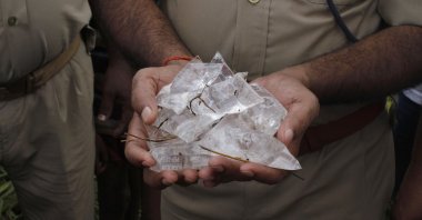 In this file photo, an Indian policeman shows packets of illegal bootleg liquor in Lucknow, India, Oct. 20, 2013. (AP Photo)
