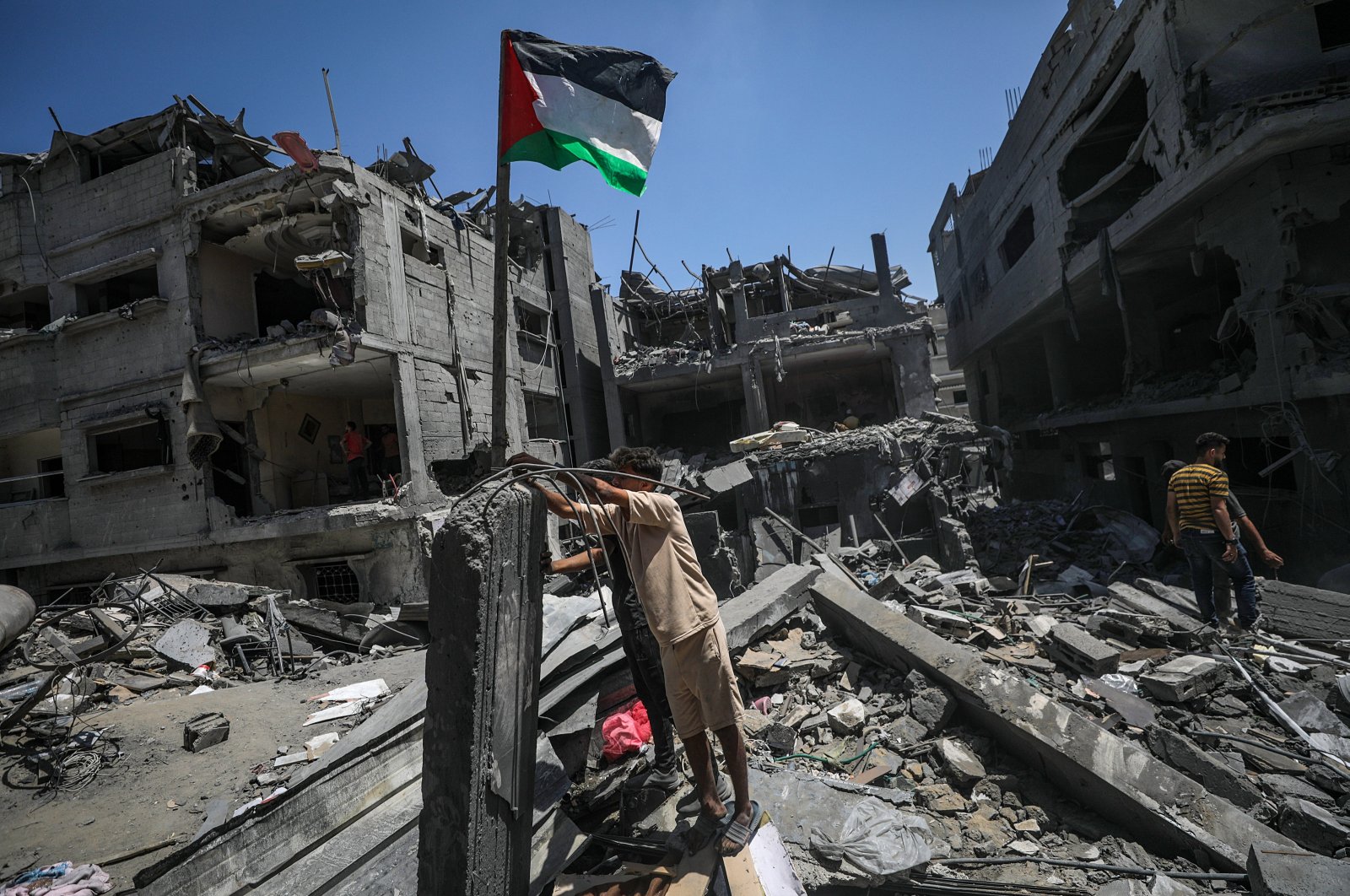 Palestinians raise a Palestinian flag next to their destroyed house following an Israeli airstrike at al-Bureij refugee camp, southern Gaza Strip, Palestine, June 18, 2024. (EPA Photo)