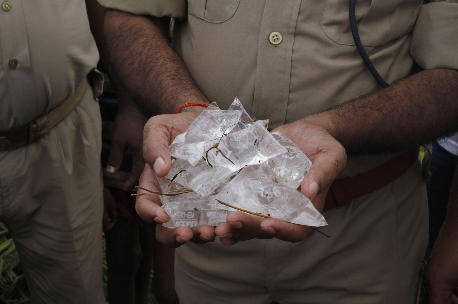 In this file photo, an Indian policeman shows packets of illegal bootleg liquor in Lucknow, India, Oct. 20, 2013. (AP Photo)