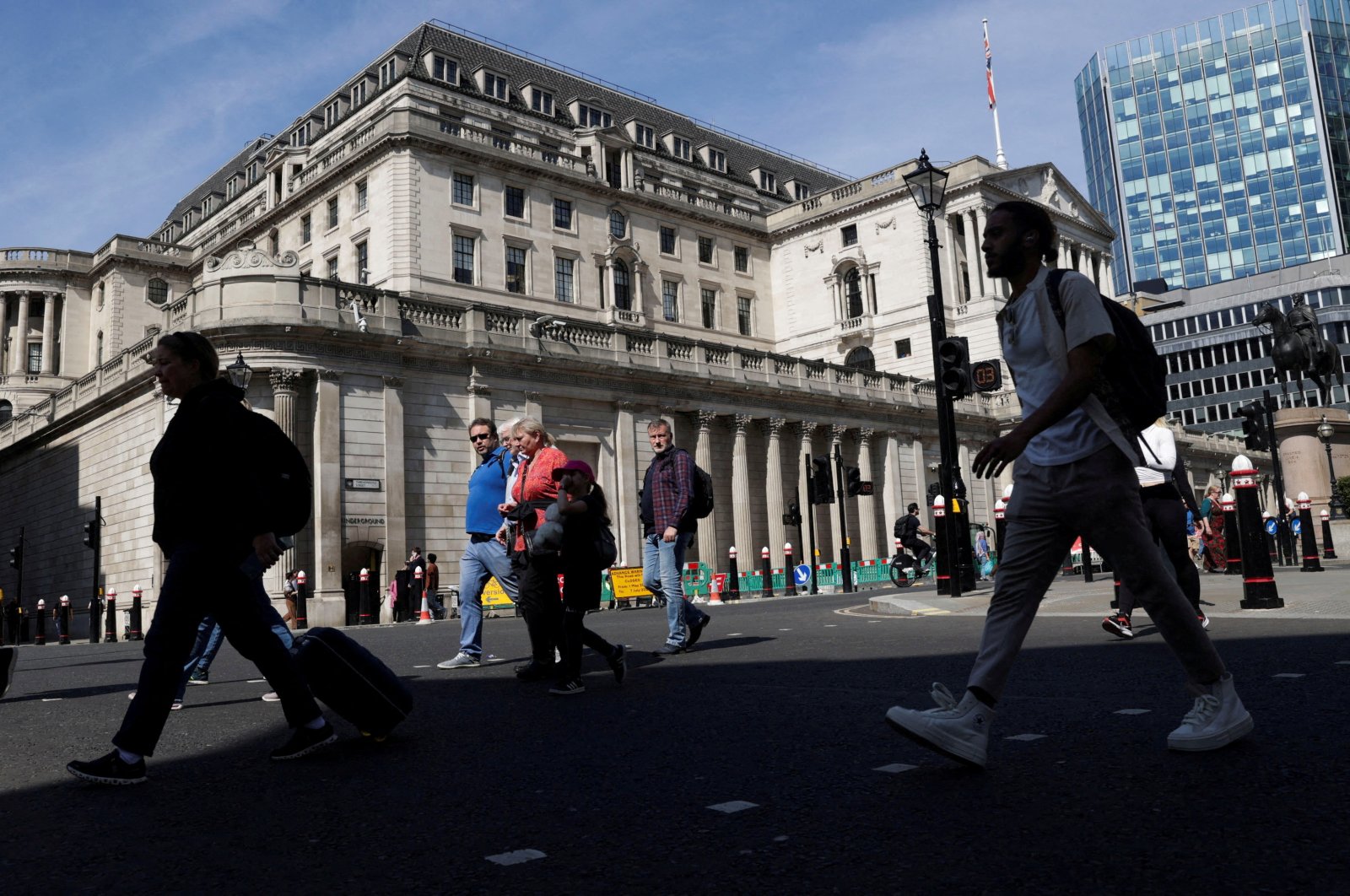 People walk past the Bank of England building in London, Britain, May 8, 2024. (Reuters Photo)