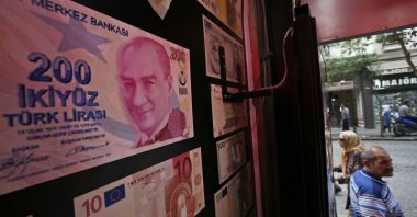 An oversized copy of a TL 200 banknote featuring a photo of modern Türkiye's founder Mustafa Kemal Atatürk decorates a currency exchange shop, Istanbul, Türkiye, Aug. 17, 2018. (AP Photo)