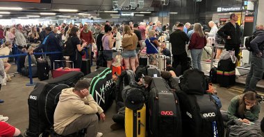 Passengers line up outside Terminal 1 after an overnight power cut led to disruptions and cancellations at Manchester Airport, Manchester, Britain, June 23, 2024. (Reuters Photo)