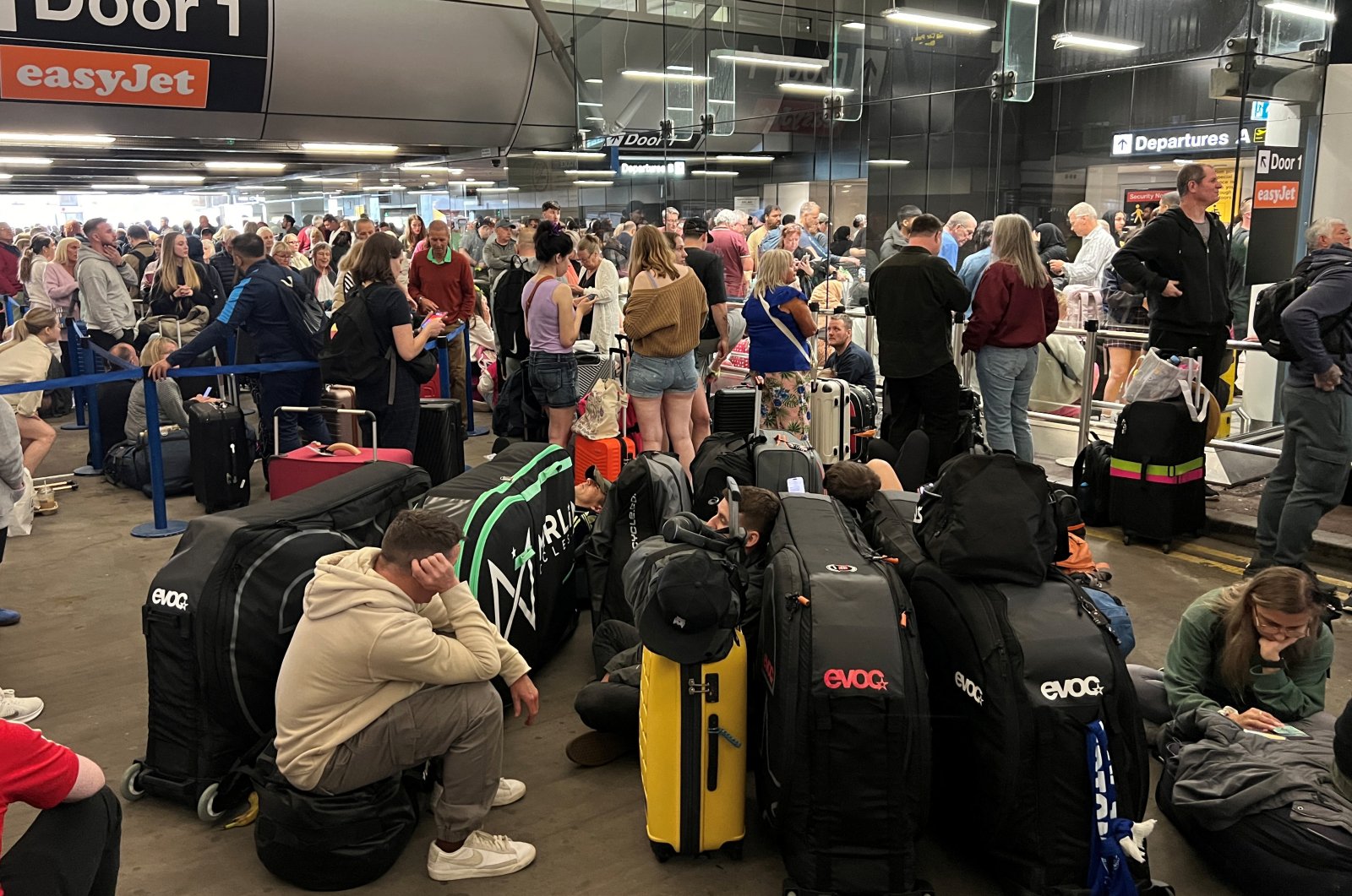 Passengers line up outside Terminal 1 after an overnight power cut led to disruptions and cancellations at Manchester Airport, Manchester, Britain, June 23, 2024. (Reuters Photo)