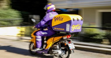 An employee of the Turkish fast grocery-delivery company Getir rides to deliver an online delivery in Istanbul, Türkiye, Nov. 12, 2021. (Reuters Photo)