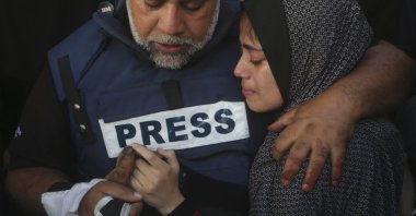Al Jazeera journalist Wael al-Dahdouh holds the hand of his son Hamza, who also worked for Al Jazeera and was killed in an Israeli airstrike in Rafah, Gaza Strip, Jan. 7, 2024. (AP Photo)