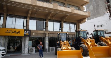 A man stands in front of a shop selling U.S. Caterpillar construction equipment in the al-Jadriya neighborhood in Baghdad, Iraq, May 30, 2024. (AFP Photo)