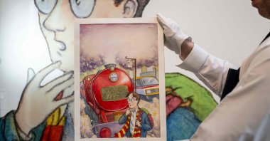 An art handler holds Thomas Taylor’s original cover art for J.K. Rowling&#039;s &quot;Harry Potter and the Philosopher’s Stone” at Sotheby’s in New York, U.S., June 25, 2024. (AFP Photo)