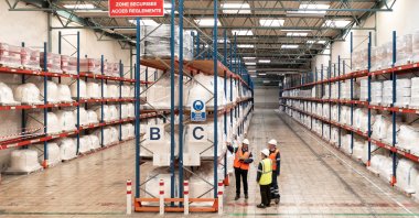 Workers look at bags of rare earth compounds in a rare earth processing plant owned by Belgian chemicals group Solvay, located in La Rochelle, France, in this undated handout picture. (Reuters Photo)