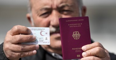 Mehmet Ali Yiğit, who has been living in Germany for more than 50 years, shows his German passport and Turkish ID after he voted at the Gruga Hall in Essen, Germany, April 27, 2023. (AP Photo)