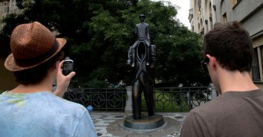 Tourists look at a statue of famous German-language writer Franz Kafka in central Prague, Czechia, July 3, 2013. (Reuters Photo)