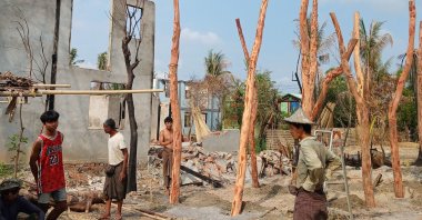 People rebuilding temporary homes near a destroyed building following fighting between Myanmar's military and the Arakan Army (AA) ethnic minority armed group in a village in Minbya Township, Rakhine State, Myanmar, May 21, 2024. (AFP Photo)
