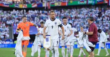 England&#039;s Harry Kane (C) holds the commemorative match pennant as he removes his anthem jacket before the UEFA Euro 2024 group stage match between England and Slovenia at Cologne Stadium, Cologne, Germany, June 25, 2024. (Getty Images Photo)