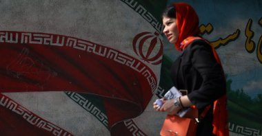 An Iranian woman passes in front of a mural with the Iranian flag on a street in Tehran, Iran, June 29, 2024. (Reuters Photo)